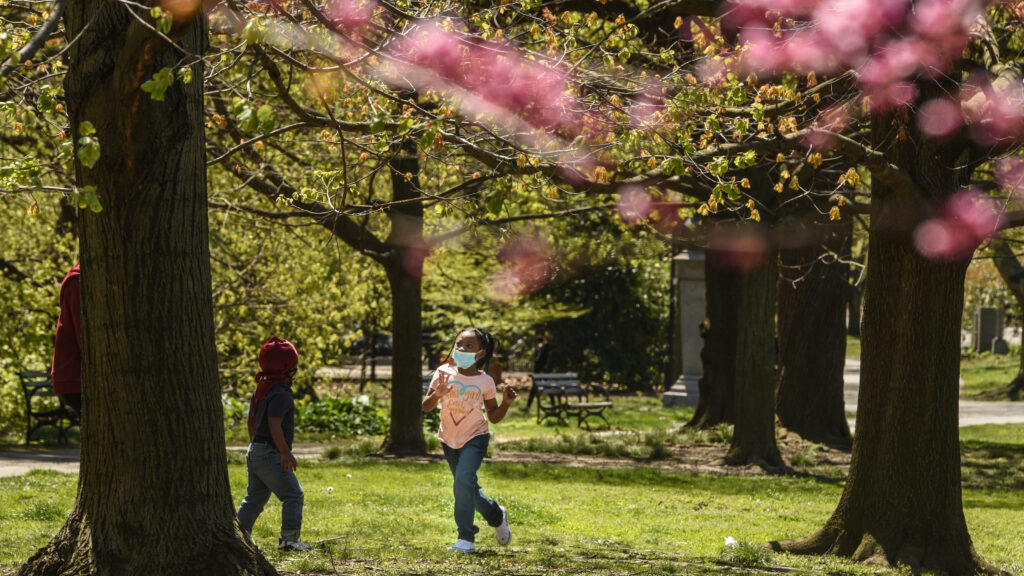 A child wears a protective mask while playing in April in Prospect Park in the Brooklyn borough of New York City.