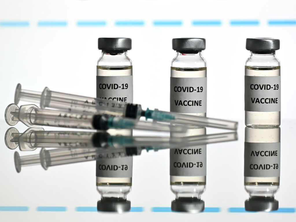 An illustration picture shows vials with COVID-19 vaccine stickers attached and syringes with the logo of U.S. biotechnology company Moderna on November 17. An illustration picture shows vials with COVID-19 vaccine stickers attached and syringes with the logo of U.S. biotechnology company Moderna on November 17.