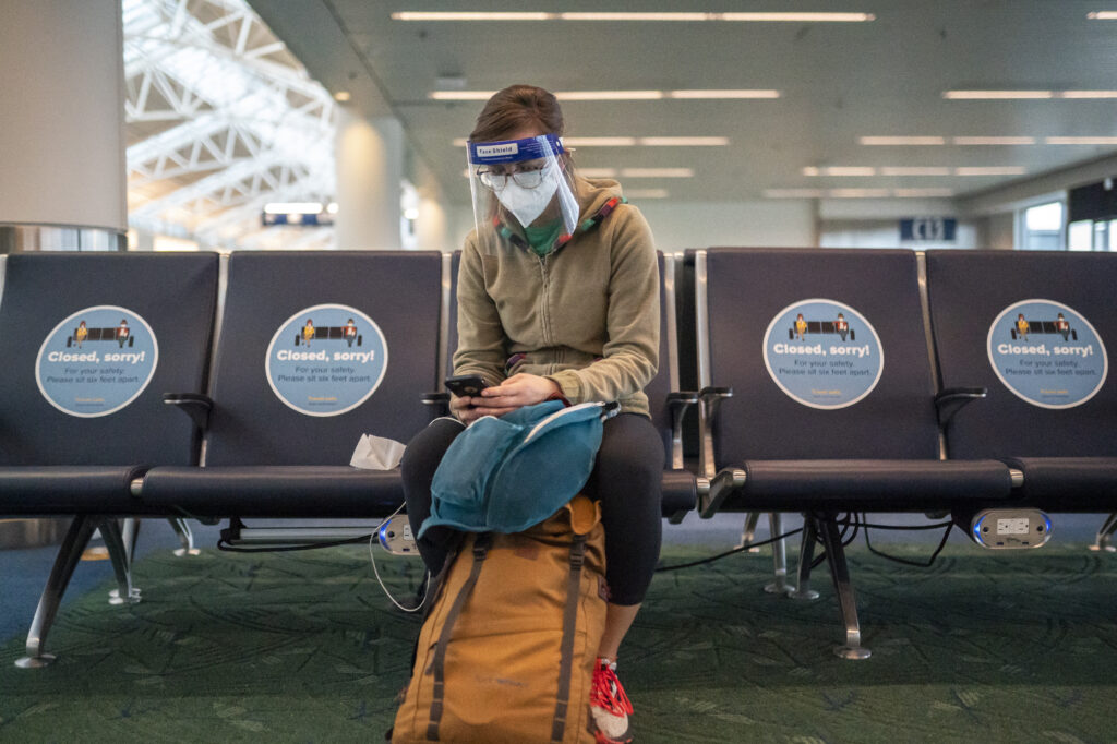 A traveler waits for a flight at Portland International Airport in Oregon last week. Public health experts say it’s important that people who traveled or gathered with others are especially careful over the next two weeks. A traveler waits for a flight at Portland International Airport in Oregon last week. Public health experts say it's important that people who traveled or gathered with others are especially careful over the next two weeks. (Nathan Howard/Getty Images)