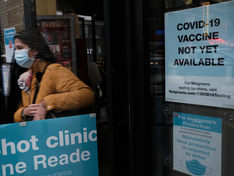A woman walks out of a drugstore in Times Square