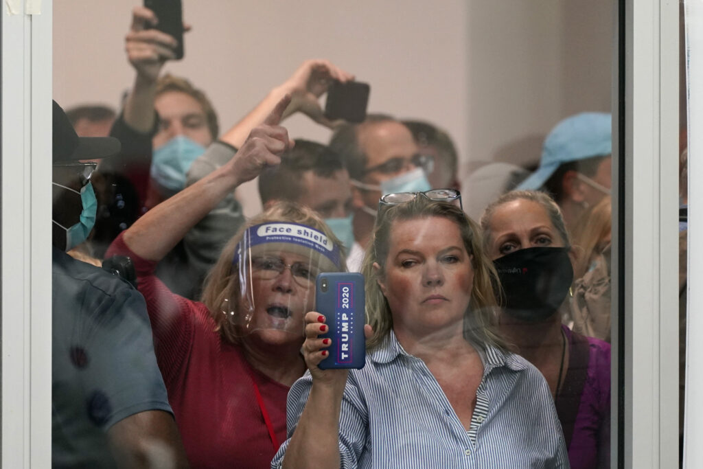 Election 2020 Michigan Voting People wanting to be election challengers yell as they look through the windows of the central counting board as police were helping to keep additional challengers from entering due to overcrowding