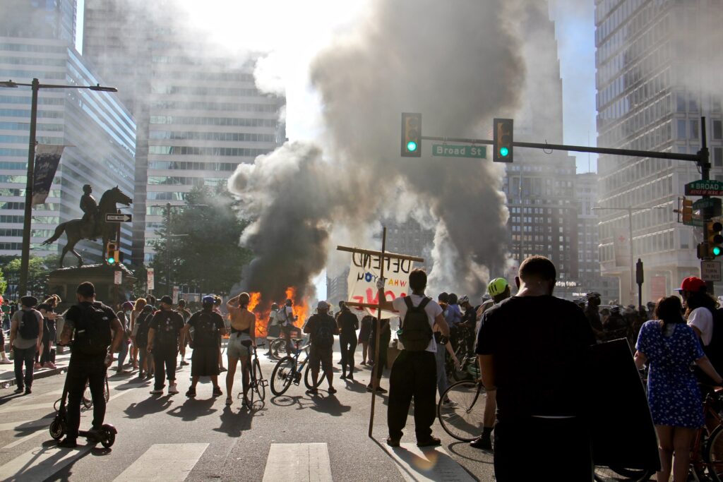 2020 05 30-e lee-philadelphia-protest and rioting Smoke from burning police cars rises over protesters at Broad Street and JFK Boulevard. (Emma Lee/WHYY)