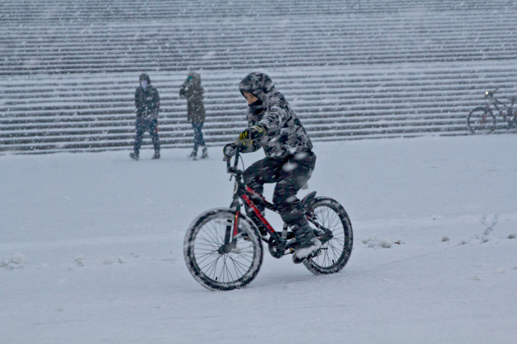 Snow revelers outside the Philadelphia Art Museum. (Kimberly Paynter/WHYY) A person rides a bike during a snow storm outside the Philly Art Museum