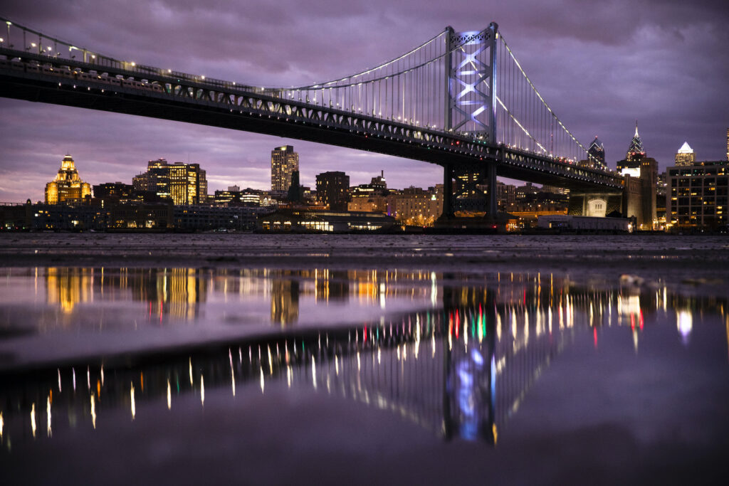New Jersey Daily Life The Benjamin Franklin Bridge spanning the Delaware River between Camden N.J., foreground, and Philadelphia is reflected the mud revealed amid low and high tide, Thursday, Dec. 5, 2019. (AP Photo/Matt Rourke)