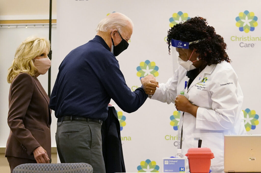 Joe Biden President-elect Joe Biden fist bumps with nurse practitioner Tabe Mase after receiving his first dose of the coronavirus vaccine at ChristianaCare Christiana Hospital in Newark, Del., Monday, Dec. 21, 2020, as Jill Biden looks on. (AP Photo/Carolyn Kaster)