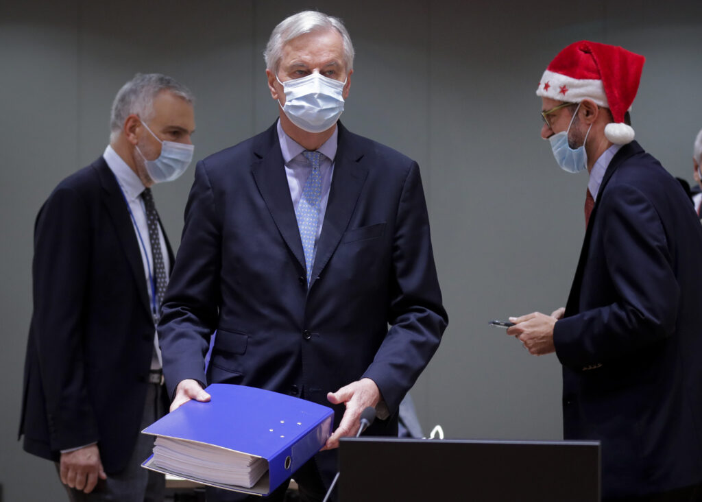 APTOPIX Belgium EU Brexit A colleague wears a Christmas hat as European Union chief negotiator Michel Barnier, center, carries a binder of the Brexit trade deal during a special meeting of Coreper, at the European Council building in Brussels, Friday, Dec. 25, 2020. (Olivier Hoslet, Pool via AP)