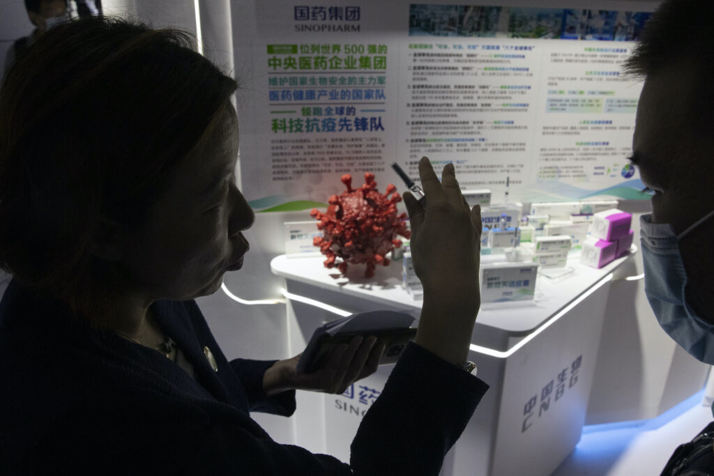 Virus Outbreak China Vaccine Development A promoter talks about the COVID-19 vaccine produced by Sinopharm subsidiary CNBG during a trade fair in Beijing on Sunday, Sept. 6, 2020. (AP Photo/Ng Han Guan)