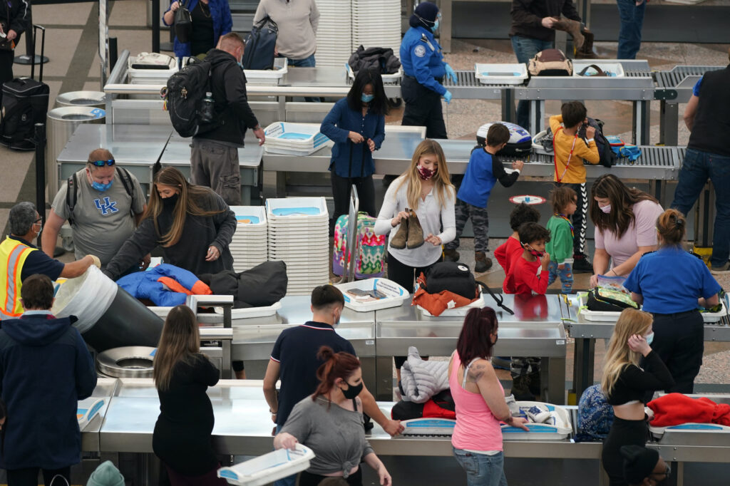 AP_coronavirus_holiday_travel_airport_122320 Travellers wear face masks while passing through the south security checkpoint in the main terminal of Denver International Airport
