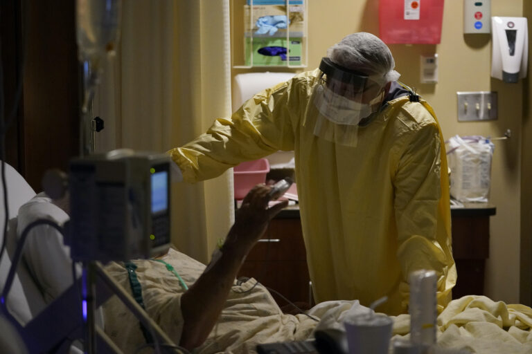 In this Nov. 24, 2020, file photo, Dr. Shane Wilson performs rounds in a portion of Scotland County Hospital set up to isolate and treat COVID-19 patients in Memphis, Mo.