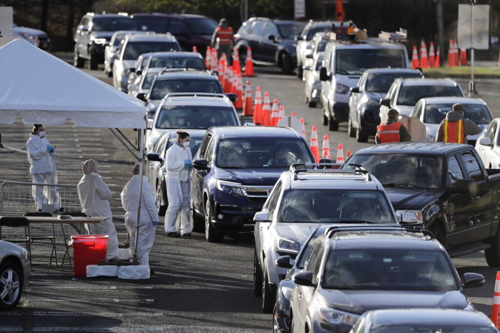 YE New Jersey Staff at a drive-thru COVID-19 testing site talk to people waiting in line in their cars at the PNC Bank Arts Center