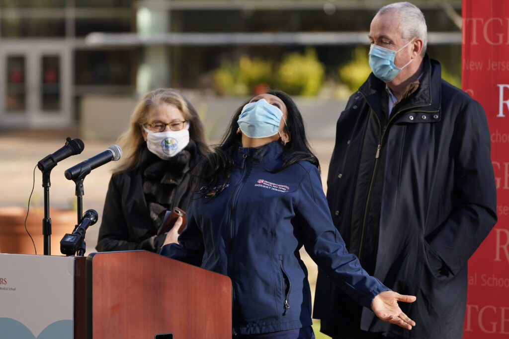 Maritza Beniquez, Phil Murphy, Judith Persichilli While New Jersey Gov. Phil Murphy, right, and New Jersey Health Commissioner Judith Persichilli, left, look on, Maritza Beniquez throws her head back and thanks God during a news conference at University Hospital's COVID-19 vaccine clinic at Rutgers New Jersey Medical School in Newark, N.J., Tuesday, Dec. 15, 2020.
