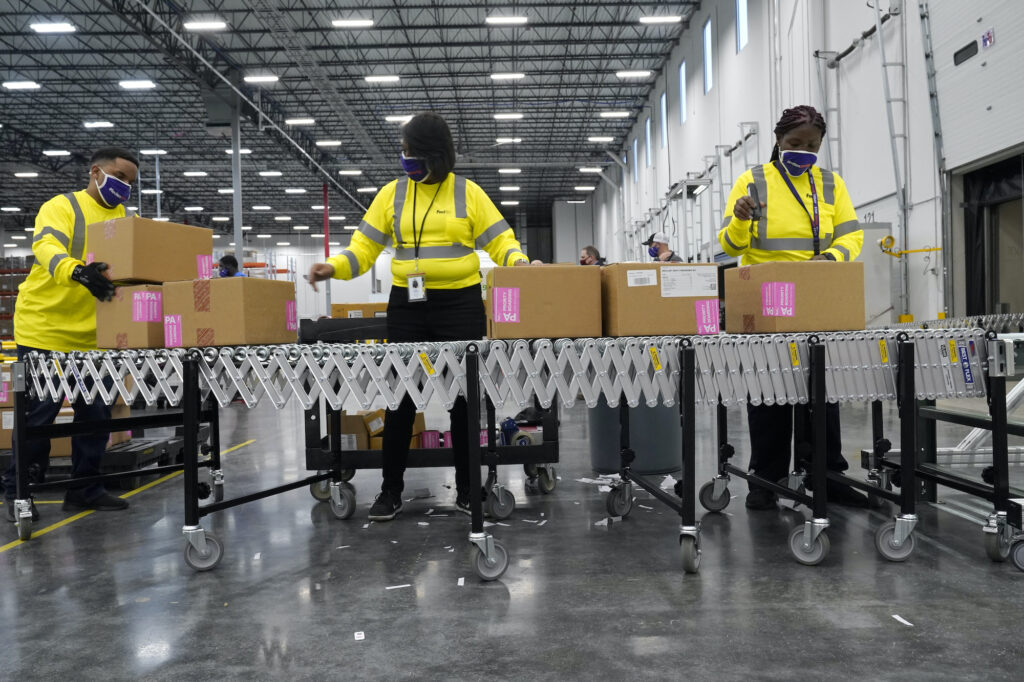 Boxes containing the Moderna COVID-19 vaccine are prepared to be shipped at the McKesson distribution center