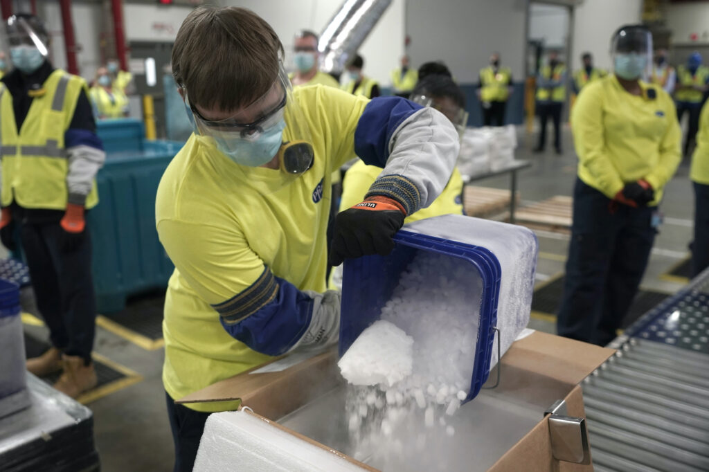 AP_coronavirus_vaccine_pfizer_121420 Dry ice is poured into a box containing the Pfizer-BioNTech COVID-19 vaccine as it is prepared to be shipped at the Pfizer Global Supply Kalamazoo manufacturing plant