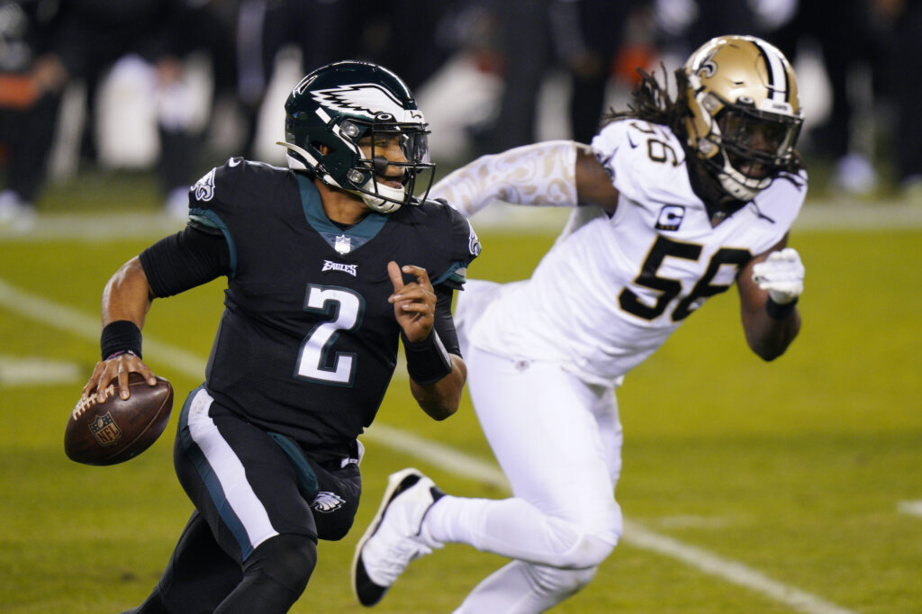 Saints Eagles Football Philadelphia Eagles' Jalen Hurts, left, scrambles past New Orleans Saints' Demario Davis