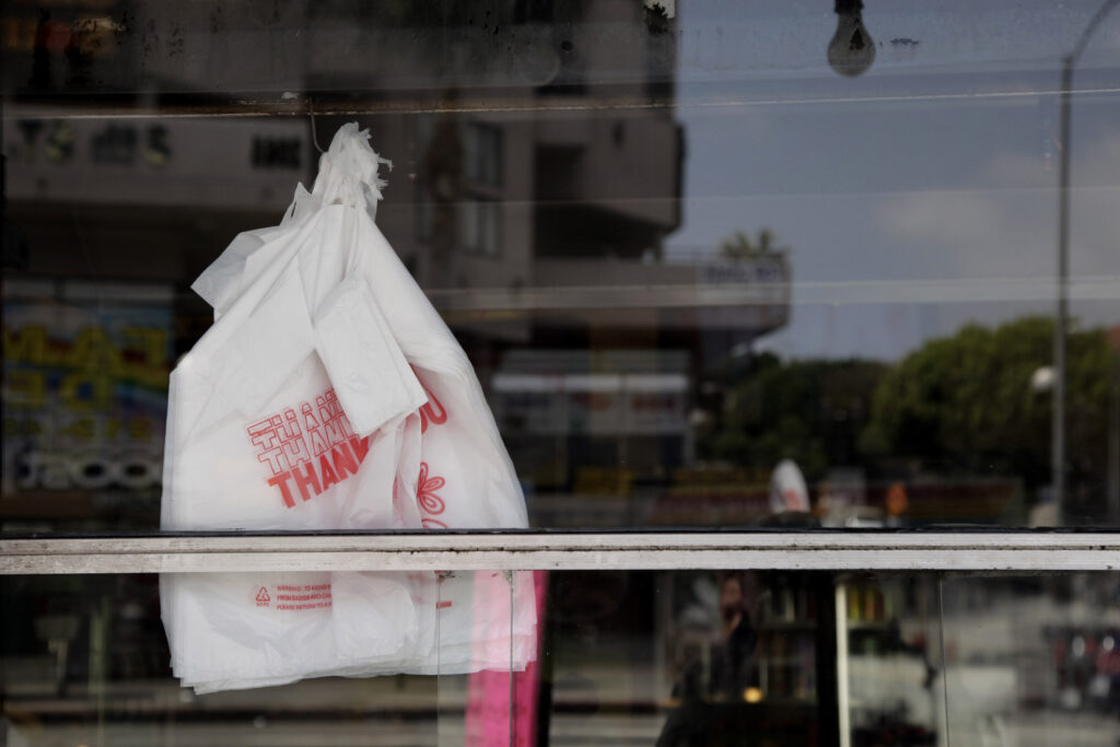 AP_plastic_bag_122920.jpg Plastic bags can be seen through the window of a restaurant
