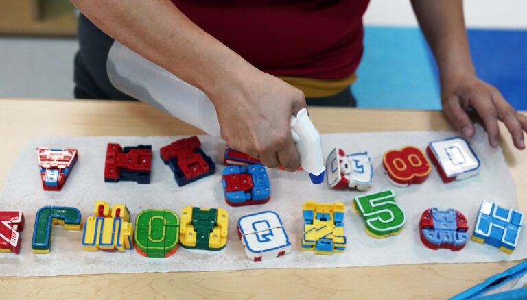 Pre-k teacher Monica Alvarez cleans and disinfects teaching tools as she prepares her classroom