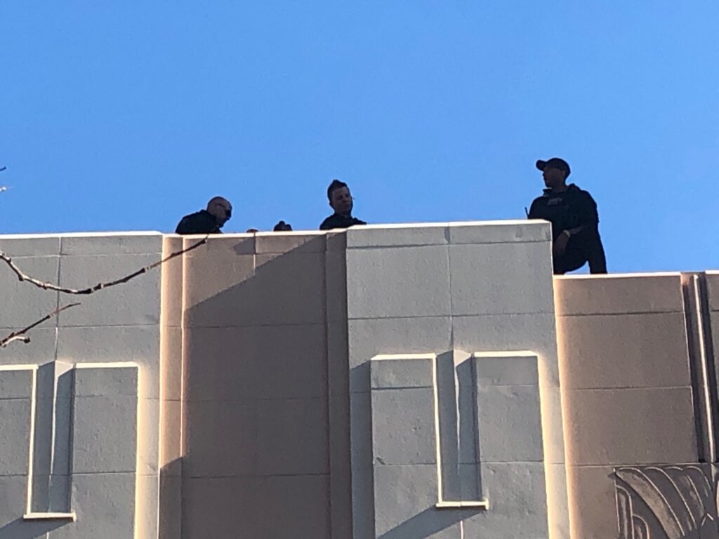 IMG_1273 Counter-snipers take up posts atop The Queen theater and the neighboring Delaware History Museum in downtown Wilmington when Biden is there. (Cris Barrish/WHYY)