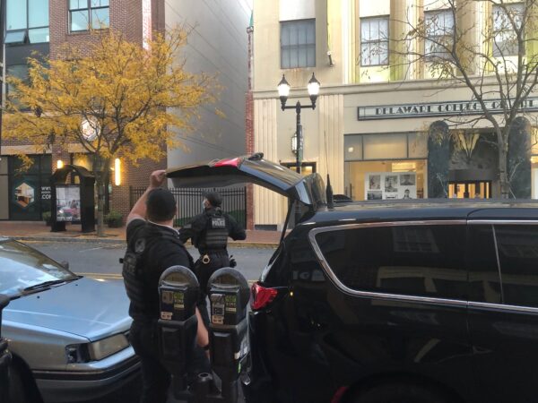 Two Secret Service agents return weapons and other equipment to their vehicle parked on Market Street, in front of WHYY's office in downtown Wilmington, after an afternoon protecting Biden. (Cris Barrish/WHYY)