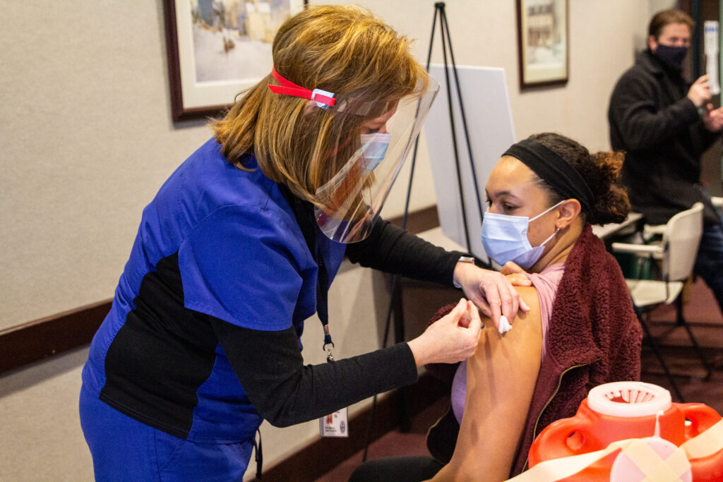 IMG_2087 Allison Brown, Union Mills Chadds Ford School District nurse, receives the Moderna COVID-19 vaccine from RN Penny Caracas. (Kimberly Paynter/WHYY)