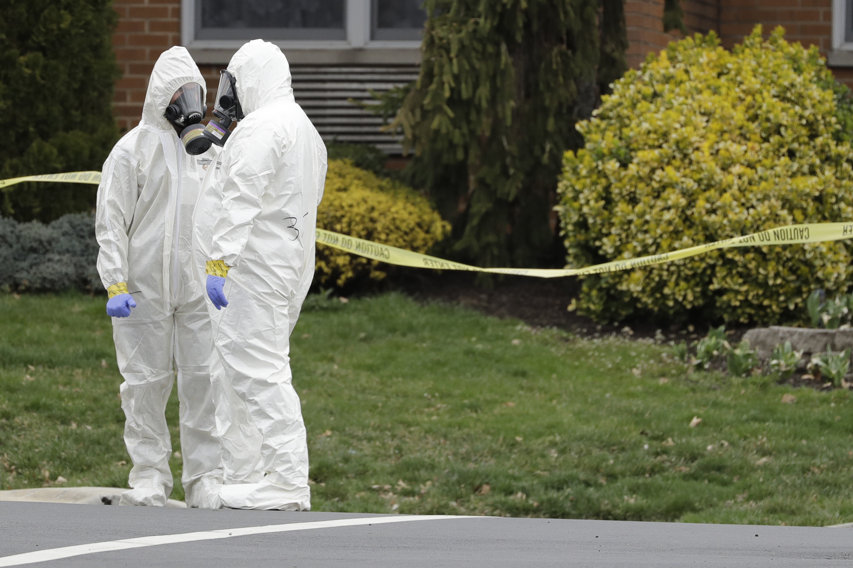 Emergency personnel in protective suits help move people out of St. Joseph's Senior Home in Woodbridge, N.J.