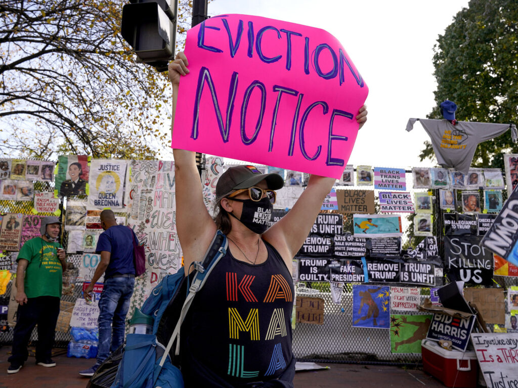 Election 2020 Protests Washington Jenn Katchmark, of Washington, holds up an eviction sign intended for Pres. Donald Trump while walking through Black Lives Matter Plaza