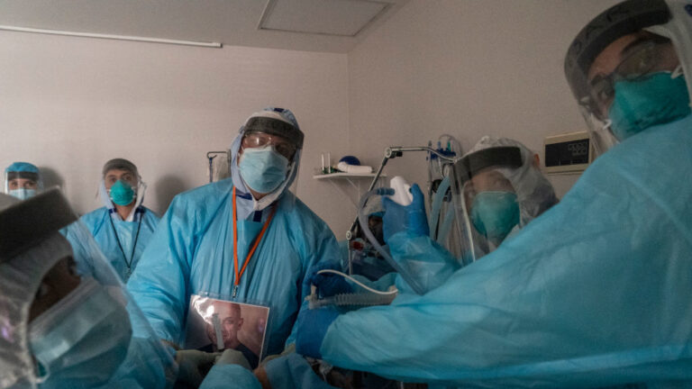 Health care workers in Houston, Texas, perform a procedure on a patient in the COVID-19 intensive care unit