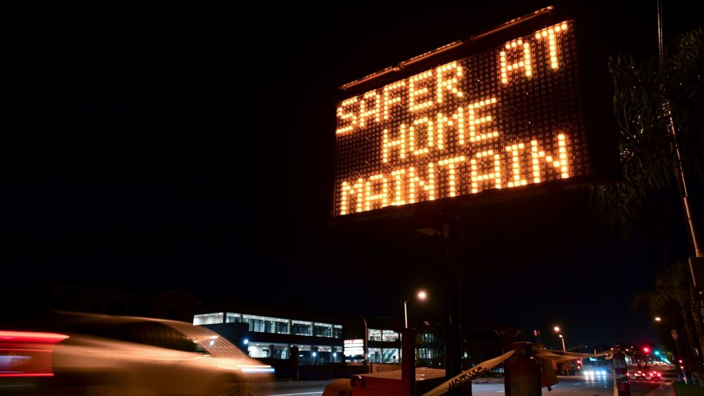 A sign reminds motorists of Los Angeles County's stay-at-home regulation. On Wednesday, the Centers for Disease Control and Prevention rolled out its revised guidelines for people potentially exposed to the coronavirus. (Frederic J. Brown/AFP via Getty Images)