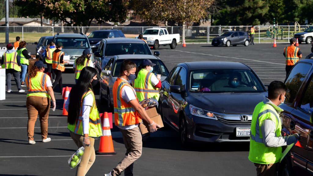 Food is loaded as drivers in their vehicles wait in line at a food distribution hosted by the Los Angeles Food Bank on Dec. 4 in Hacienda Heights, Calif. Food is loaded as drivers in their vehicles wait in line at a food distribution hosted by the Los Angeles Food Bank on Dec. 4 in Hacienda Heights, Calif. (Frederic J. Brown/AFP via Getty Images)