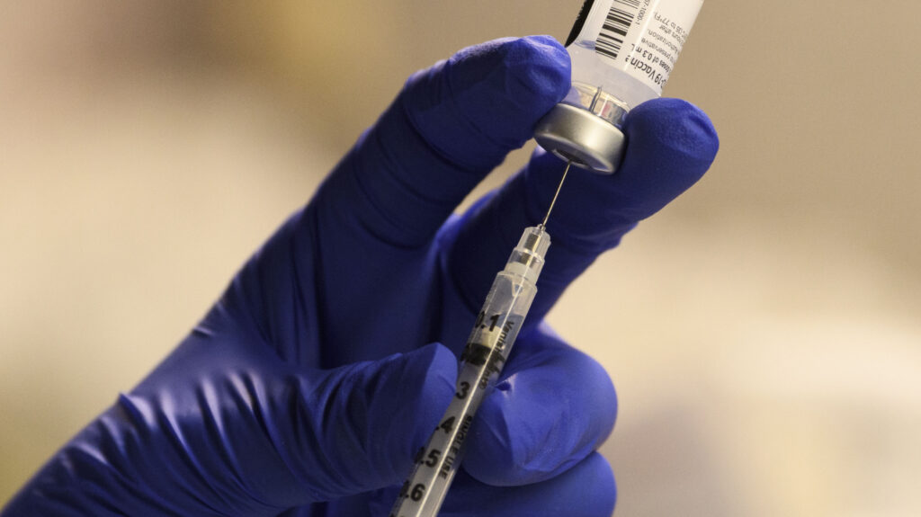 A pharmacist fills a syringe to prepare a dose of the Pfizer-BioNTech vaccine for front-line health care workers in Torrance, Calif., Saturday.