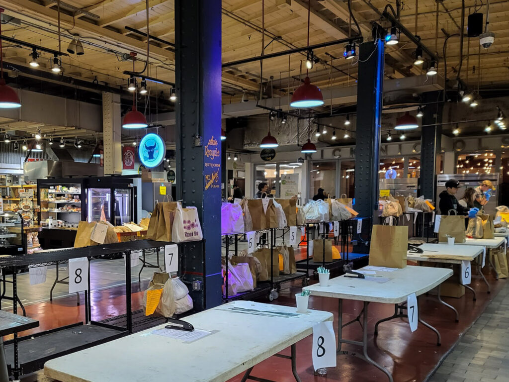readingterminalmarket-april2020coronavirus-markhenninger01 Bags of delivery groceries being prepared at Reading Terminal Market during the pandemic in April 2020.