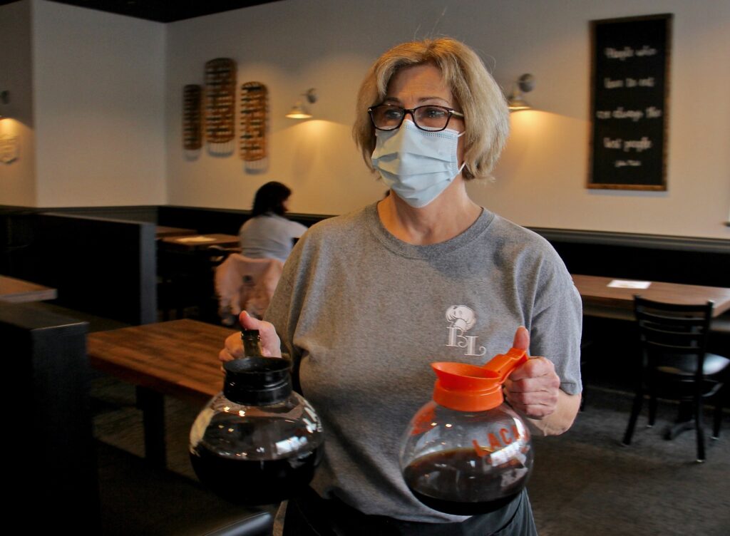2020 12 31-e lee-abington pa bonnet lane restaurant Laura Tierney, manager of Bonnet Lane Family Restaurant in Abington, Pa., serves customers in the dining room. (Emma Lee/WHYY)
