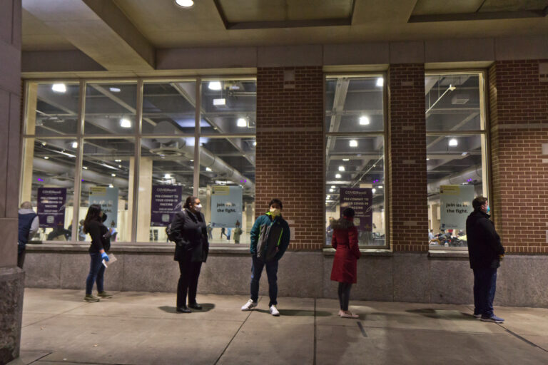 Home health workers wait in line outside Philadelphia’s community vaccination clinic at the Pennsylvania Convention Center.