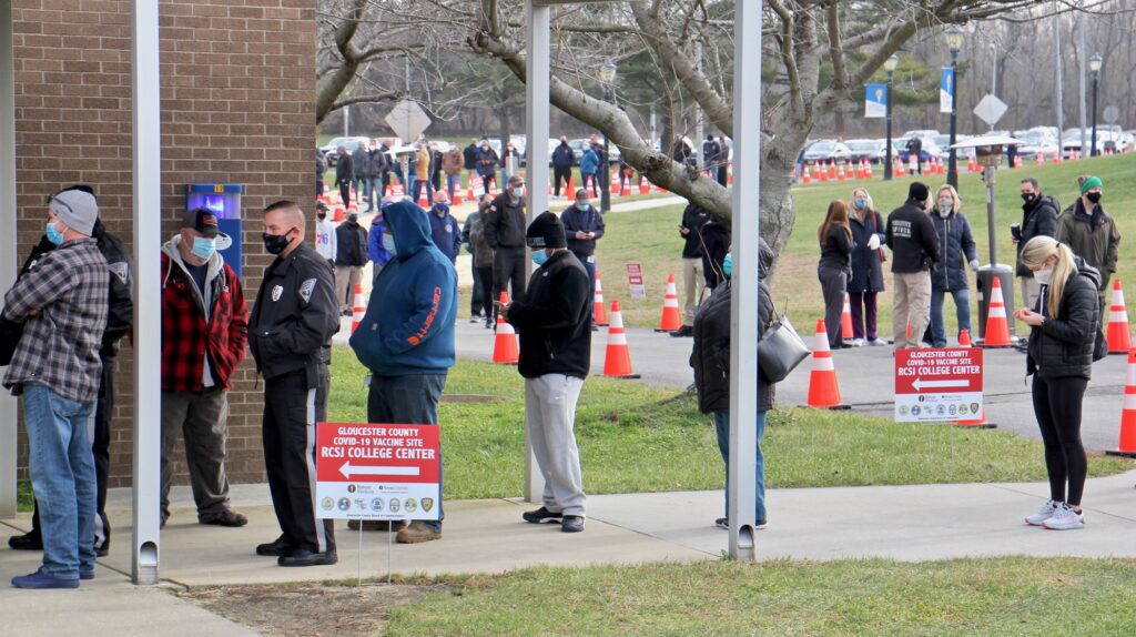 2021 01 11-e lee-sewell rowan college of south jersey-mass vaccination covid 19 waiting line phone Hundreds of people line up outside to be vaccinated against COVID-19.