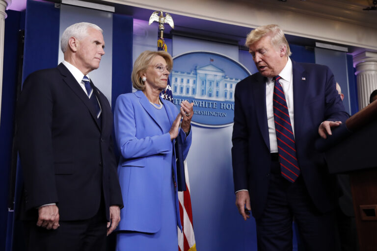 President Donald Trump leaves the podium after a briefing in the James Brady Press Briefing Room, Friday, March 27, 2020, in Washington, as Vice President Mike Pence and Education Secretary Betsy DeVos watch, (AP Photo/Alex Brandon)