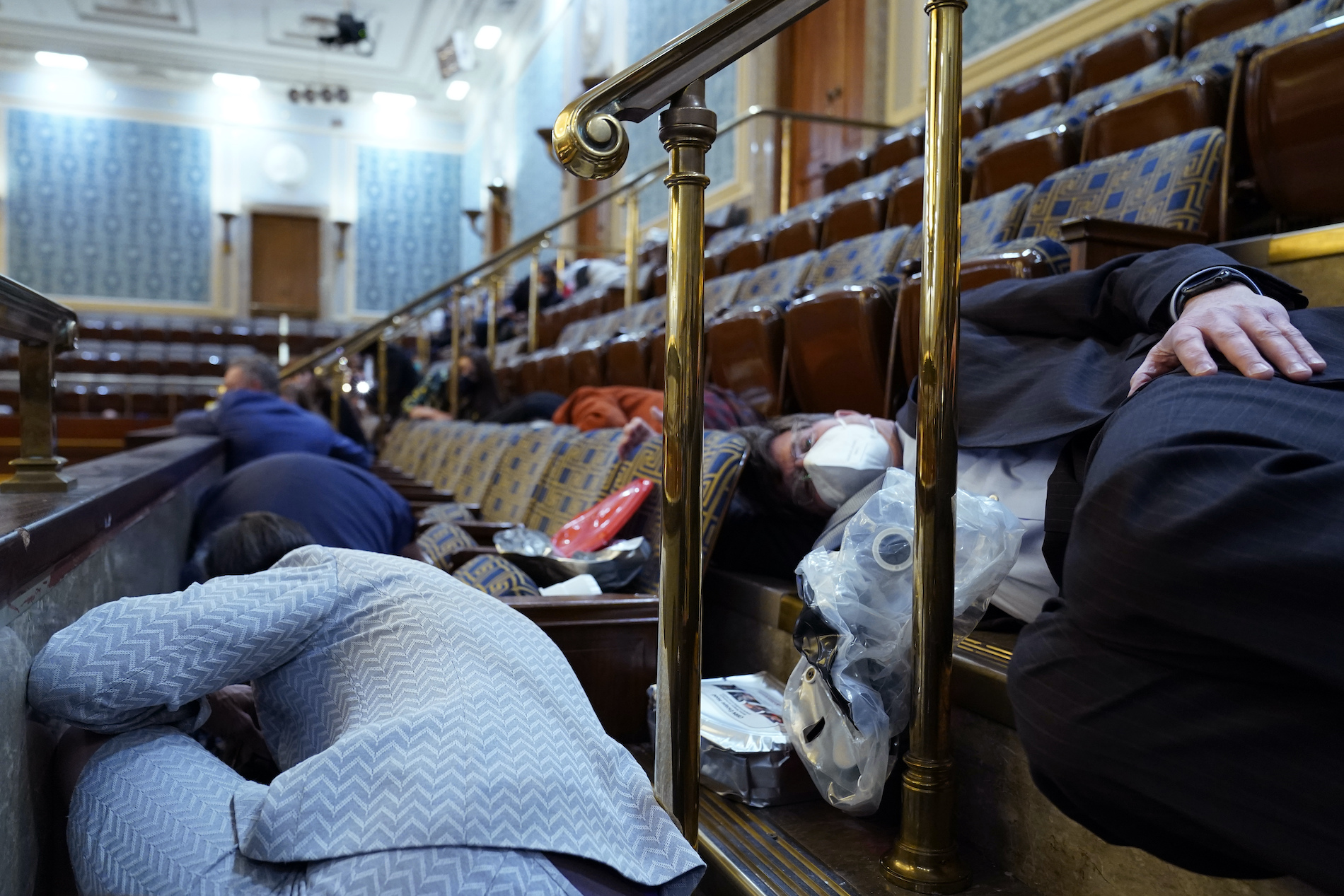 People shelter in the House gallery as pro-Trump rioters try to break into the House Chamber at the U.S. Capitol on Wednesday, Jan. 6, 2021, in Washington.