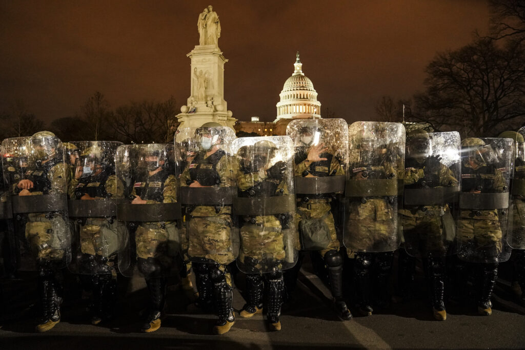 APTOPIX Electoral College Protests District of Columbia National Guard stand outside the Capitol, Wednesday night, Jan. 6, 2021, after a day of rioting protesters. It's been a stunning day as a number of lawmakers and then the mob of protesters tried to overturn America's presidential election, undercut the nation's democracy and keep Democrat Joe Biden from replacing Trump in the White House. (AP Photo/John Minchillo)