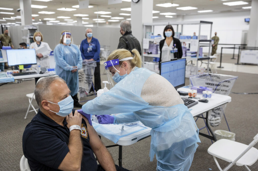 Virus Outbreak New Jersey Sergeant Brian Patrick McKnerney, of the New Jersey State Police, receives a COVID-19 vaccination at the Morris County, vaccination site, in Rockaway, NJ, Friday, Jan. 8, 2021. (Sarah Blesener/The New York Times via AP, Pool)