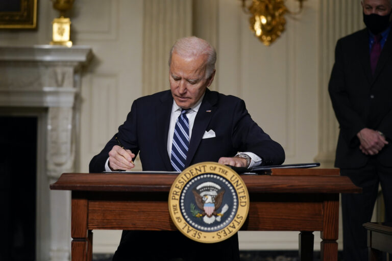 President Joe Biden signs an executive order in the State Dining Room of the White House. (AP Photo/Evan Vucci)