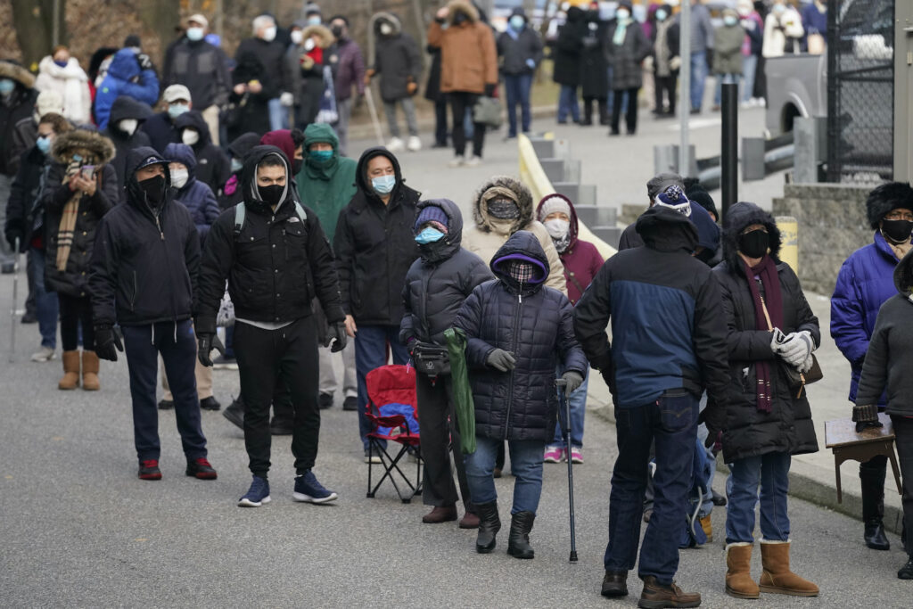 Virus Outbreak In this Jan. 21, 2021, file photo, people wait in line for the COVID-19 vaccine in Paterson, N.J. (AP Photo/Seth Wenig)