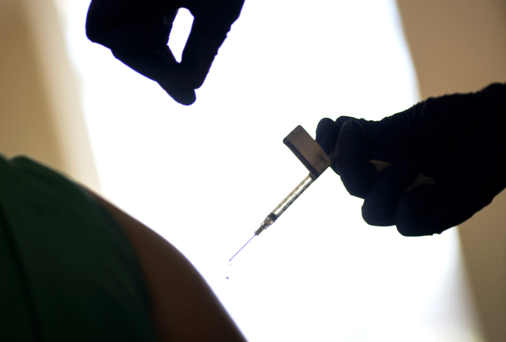 Virus Outbreak Preferential Treatment In this Tuesday, Dec. 15, 2020 file photo, a droplet falls from a syringe after a health care worker was injected with the Pfizer-BioNTech COVID-19 vaccine in Providence, R.I. (AP Photo/David Goldman)