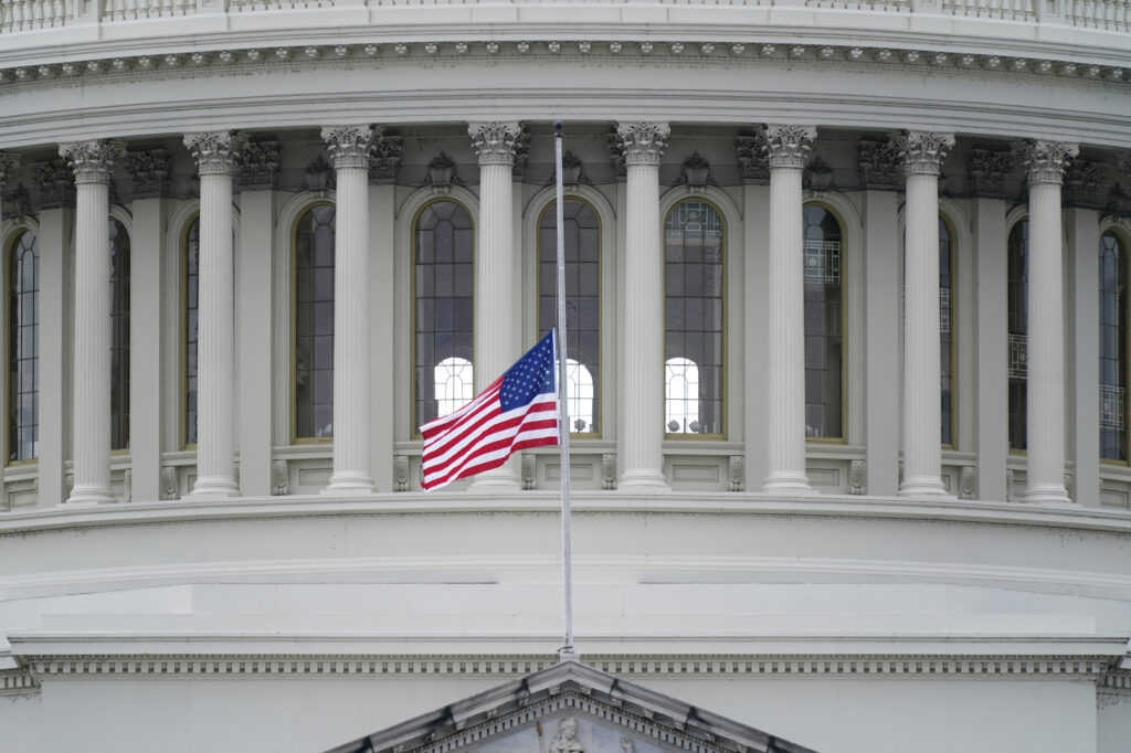 An American flag flies at half-staff in remembrance of U.S. Capitol Police Officer Brian Sicknick above the Capitol Building