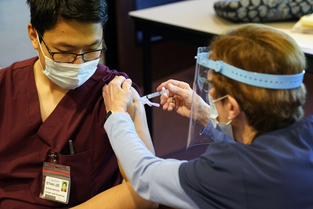Virus Outbreak Vaccine Pennsylvania Pat Moore administers a covid-19 vaccine to Ethan Lee
