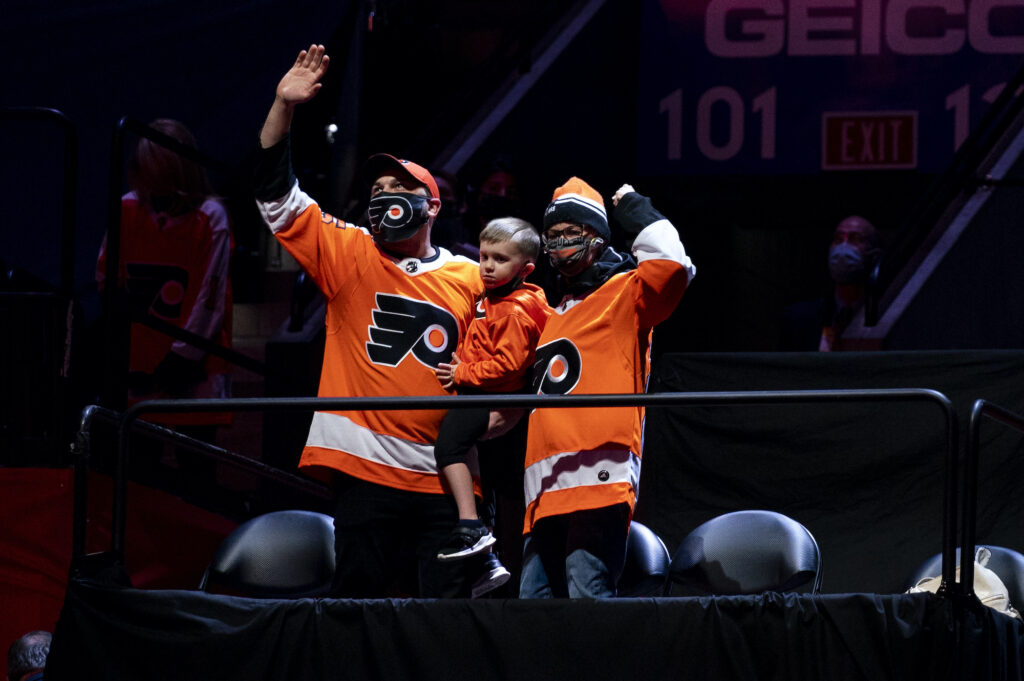 Penguins Flyers Hockey Josh and Amanda Hatheway, accompanied by their young son, wave from their seats at the Wells Fargo Center.