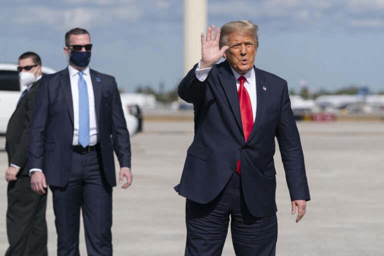 Former President Donald Trump waves to the members of the media