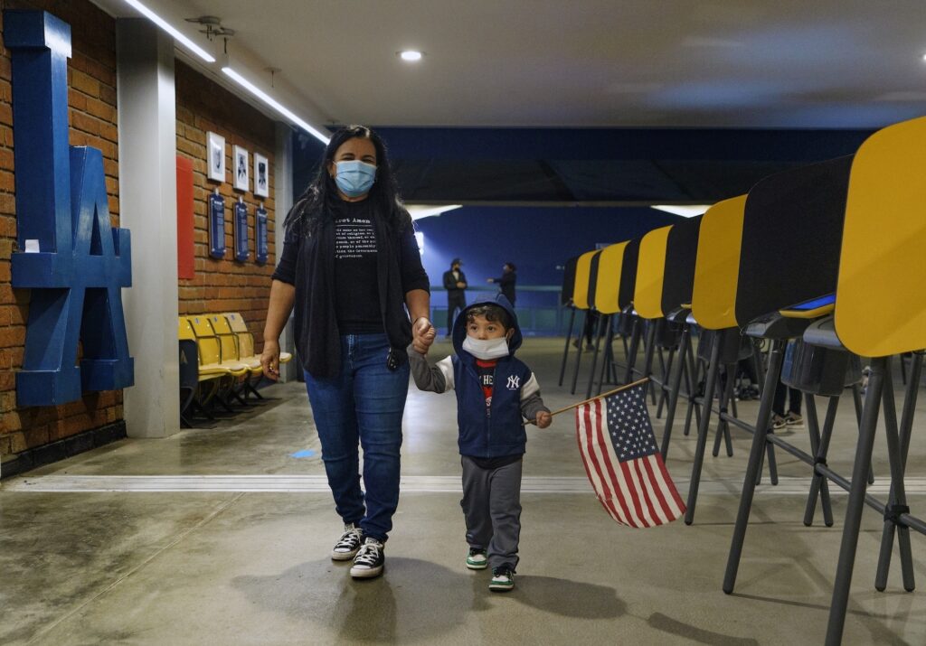 AP_voting_election_reforms_ballot_012421 Lisa Carrera and her 2-year-old grandson Maverick hold hands as they walk inside a polling place