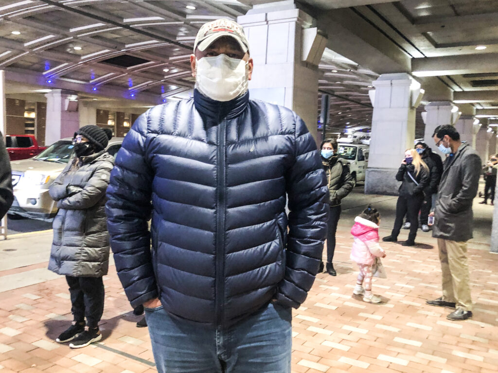 IMG_4619 Julio Polanco, a behavioral care specialist at Children’s Crisis Treatment Center, stands in line at Philadelphia’s community vaccination clinic at the Pennsylvania Convention Center. (Nina Feldman/WHYY)