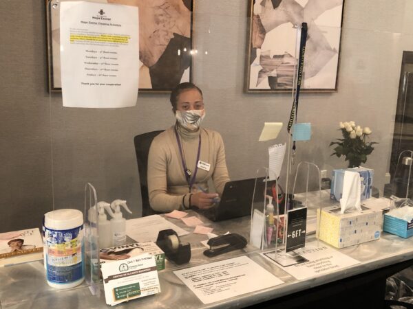 Christina Johnson helps Hope Center tenants from her perch at the information desk. (Cris Barrish/WHYY)