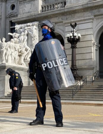 A police officer with a shield stands guard outside the Pa. Capitol