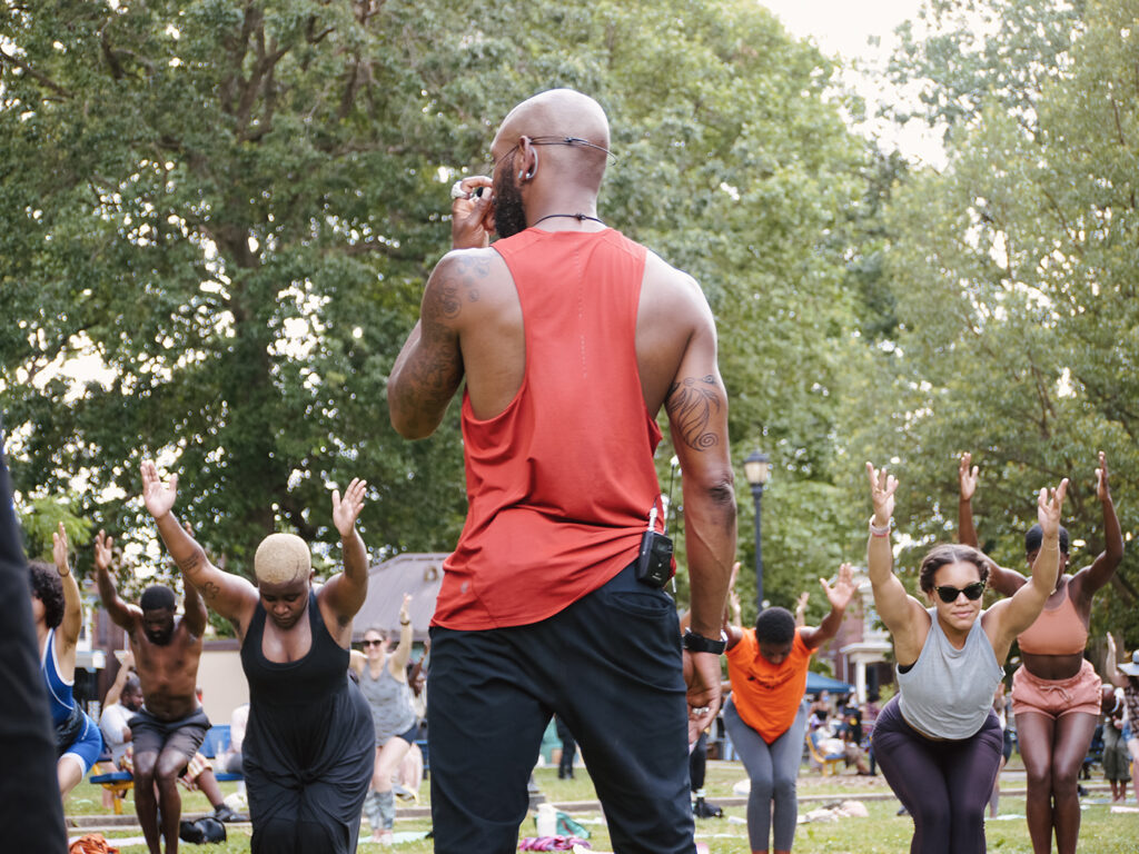Spirits Up! A Black yoga instructor from Spirits Up! leads an exercise class outside for people of color