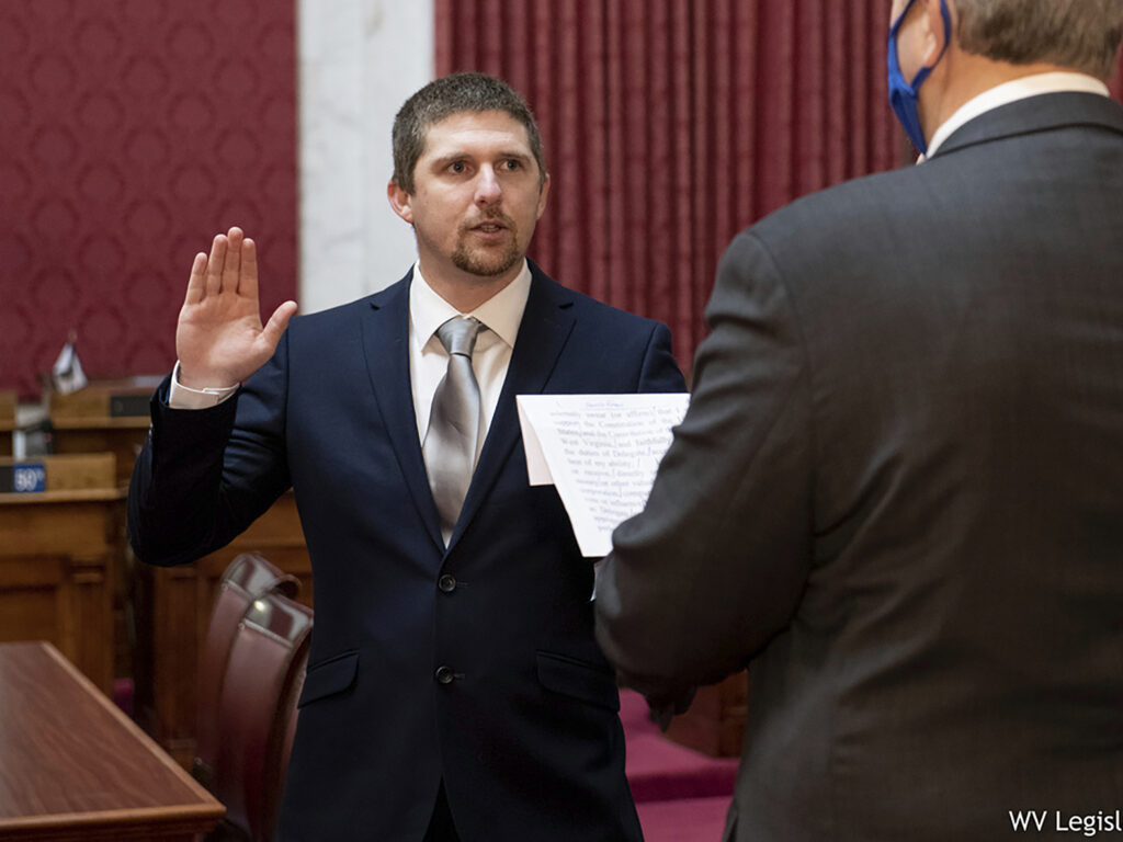 W. Va. Del. Derrick Evans, shown taking the oath of office in Charleston on Dec. 14, was seen in a video as part of the group of pro-Trump rioters who forced their way into the U.S. Capitol on Wednesday. W. Va. Del. Derrick Evans, shown taking the oath of office